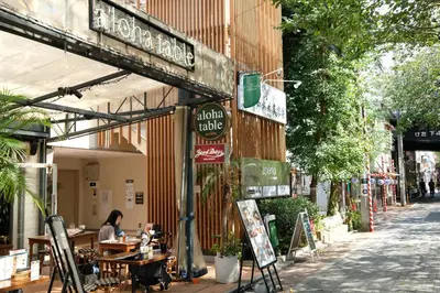 a woman sitting at a table outside of a restaurant at COCO Nakameguro301 in Tokyo