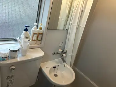 a bathroom with a toilet and a sink and a mirror at COCO Nakameguro302 in Tokyo