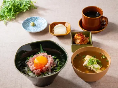 a table with bowls of food and a cup of coffee at APA Hotel Komagome Ekimae in Tokyo