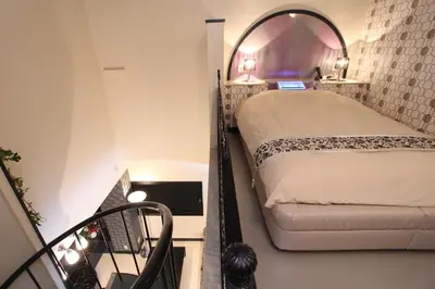 a small bedroom with a bed and a mirror at HOTEL DCUBE in Tokyo