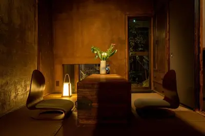 a room with a fireplace with two chairs and a candle at cyashitsu ryokan asakusa in Tokyo