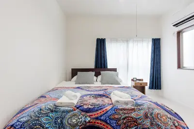 a bedroom with a bed with two white towels on it at Gracias Arakawa - Great Access to UENO & ASAKUSA area in Tokyo