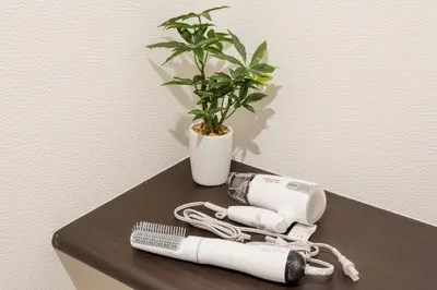 a hair dryer and a potted plant on a table at Gracias Arakawa - Great Access to UENO & ASAKUSA area in Tokyo