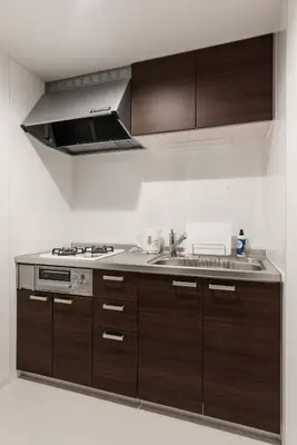 a kitchen with wooden cabinets and a stove top oven at Gracias Arakawa - Great Access to UENO & ASAKUSA area in Tokyo