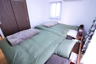 two twin beds in a bedroom with green sheets at Central Field 5-6F in Tokyo