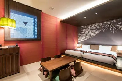 a bedroom with a bed and a wooden table at La'gent Hotel Shinjuku Kabukicho in Tokyo