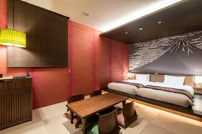a bedroom with a bed and a wooden table at La'gent Hotel Shinjuku Kabukicho in Tokyo