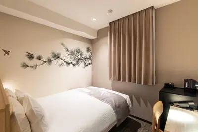 a bedroom with a bed and a desk and a window at La'gent Hotel Shinjuku Kabukicho in Tokyo