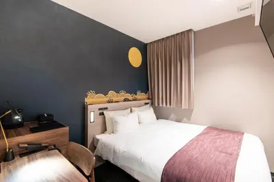 a bedroom with a bed and a desk with a chair at La'gent Hotel Shinjuku Kabukicho in Tokyo