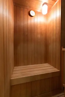 a sauna with a clock on a wooden wall at HOTEL D-WAVE Shinjuku\uff08Adult Only) in Tokyo