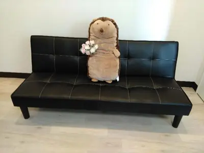 a teddy bear sitting on a leather couch with flowers at \u4e0a\u91ce\u5fa1\u5f92\u753a\u79cb\u8449\u539f\u307e\u3067\u5f92\u6b69\u570f-JR\u5fa1\u5f92\u753a\u307e\u30673\u5206-Room\u30ed\u30fc\u30bc201 in Tokyo