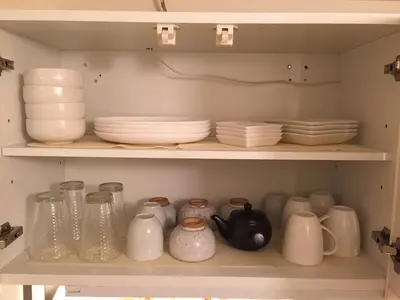 a shelf filled with dishes and pitchers and plates at Jujo Stay Sanyo Mansion in Tokyo