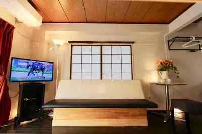 a living room with a bed and a television at Jujo Stay Sanyo Mansion in Tokyo