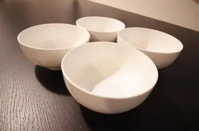 four white bowls are sitting on a table at Central Field 4F in Tokyo