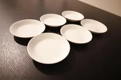 a group of white plates sitting on a table at Central Field 4F in Tokyo