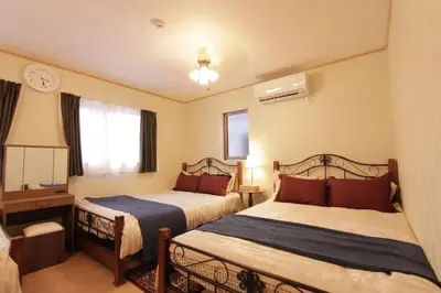 a bedroom with two beds and a clock on the wall at NY Stage \u65b0\u5bbf in Tokyo