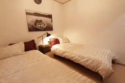 a bedroom with two beds and a lamp on a night stand at NY Stage \u65b0\u5bbf in Tokyo