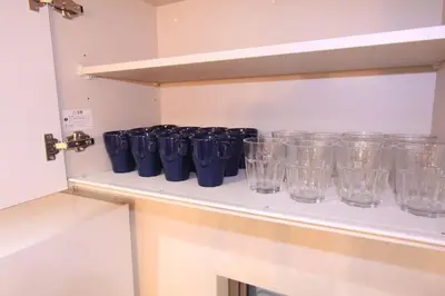 a row of blue glasses sitting on a shelf at NY Stage \u65b0\u5bbf in Tokyo