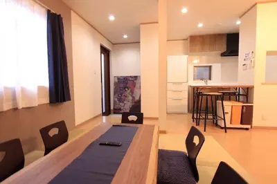 a living room with a table and chairs and a kitchen at NY Stage \u65b0\u5bbf in Tokyo