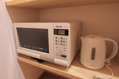 a microwave sitting on a shelf in a kitchen at NY Stage \u65b0\u5bbf in Tokyo