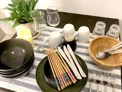 a table with black plates and chopsticks and wine glasses at Oku-Shibu Residence in Tokyo