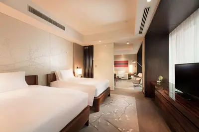 a hotel room with two beds and a flat screen tv at Conrad Tokyo in Tokyo