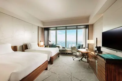 a hotel room with two beds and a flat screen tv at Conrad Tokyo in Tokyo