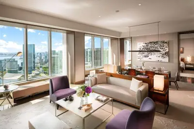 a living room with a couch and chairs and windows at Conrad Tokyo in Tokyo