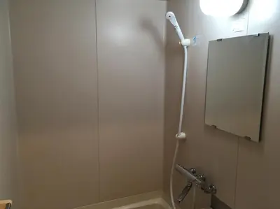 a shower stall in a bathroom with a mirror at Tokyo Stay Ikebukuro in Tokyo