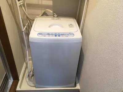 a washer and dryer in a corner of a room at Tokyo Stay Ikebukuro in Tokyo