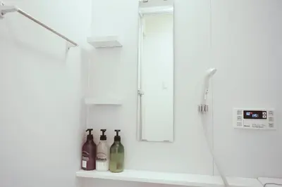 a bathroom with a shower with bottles on a shelf at ZAITO Tokyo Kikukawa Economy Inn \u5b85\u4e1c\u4e1c\u4eac\u83ca\u5ddd\u6c11\u5bbf in Tokyo
