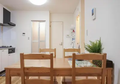 a dining room with a wooden table and chairs at ZAITO Tokyo Kikukawa Economy Inn \u5b85\u4e1c\u4e1c\u4eac\u83ca\u5ddd\u6c11\u5bbf in Tokyo