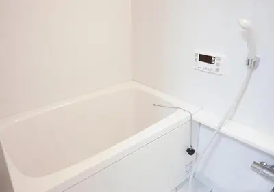 a white bathtub with a hose attached to a wall at ZAITO Tokyo Kikukawa Economy Inn \u5b85\u4e1c\u4e1c\u4eac\u83ca\u5ddd\u6c11\u5bbf in Tokyo