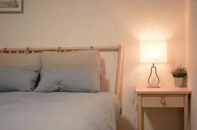 a bedroom with a bed and a lamp on a table at ZAITO Tokyo Kikukawa Economy Inn \u5b85\u4e1c\u4e1c\u4eac\u83ca\u5ddd\u6c11\u5bbf in Tokyo
