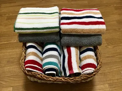 a pile of towels in a basket on a wooden floor at Ys Bed & Kitchen Tokyo #HY1 in Tokyo