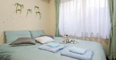 a dog sitting on top of a bed with pillows at Cosmo Mercy N-1 / Vacation STAY 12990 in Tokyo