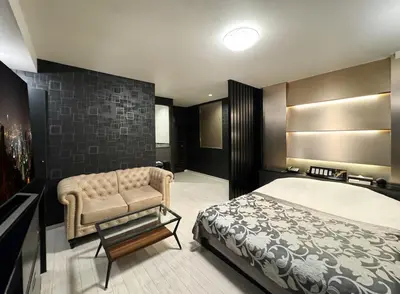 a bedroom with a bed and a chair in it at Hotel Gran Villa in Tokyo
