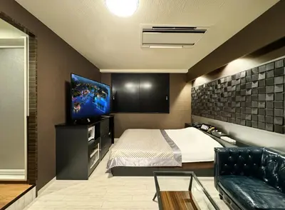a bedroom with a bed and a flat screen tv at Hotel Gran Villa in Tokyo
