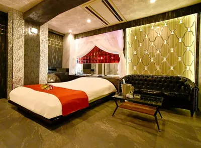 a bedroom with a large bed and a table at Hotel Gran Villa in Tokyo