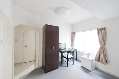 a room with a desk and a table with a window at Shin-Okubo City Hotel in Tokyo