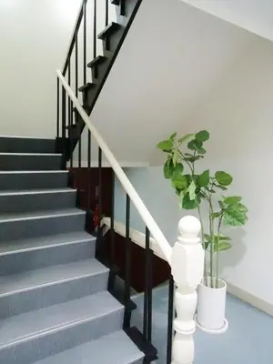 a stairway with a plant in a white vase at Shin-Okubo City Hotel in Tokyo