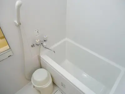 a white bathroom with a toilet and a sink at Shin-Okubo City Hotel in Tokyo