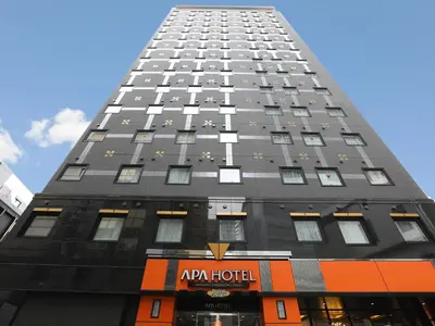 a tall black building with a hotel sign on it at APA Hotel Shinjuku Kabukicho Chuo in Tokyo