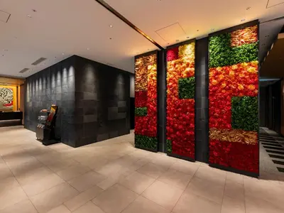 a wall of red and green plants in a lobby at Mitsui Garden Hotel Ginza-gochome in Tokyo
