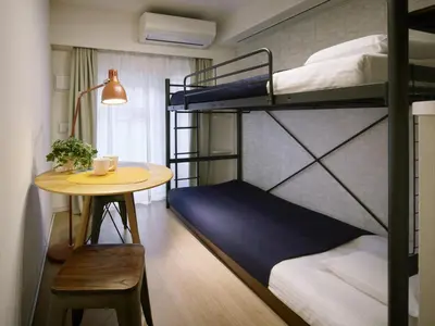 a room with two bunk beds and a table at KARIO Sasazuka in Tokyo