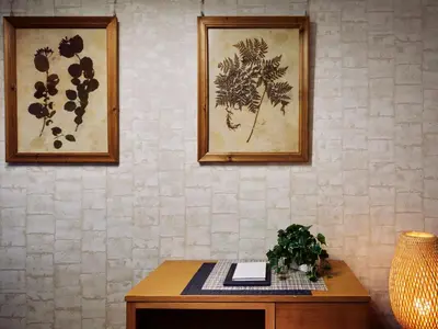 a table with a plant and two pictures on a wall at KARIO Sasazuka in Tokyo