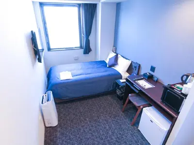 a hotel room with a bed and a desk and a window at HOTEL LiVEMAX Akasaka in Tokyo