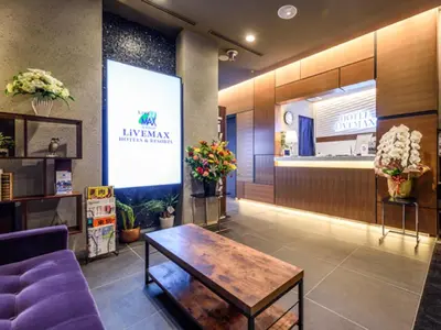 a lobby with a purple couch and a table at HOTEL LiVEMAX Asakusabashi-Ekimae in Tokyo