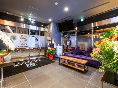 a living room with a purple couch and a table at HOTEL LiVEMAX Asakusabashi-Ekimae in Tokyo