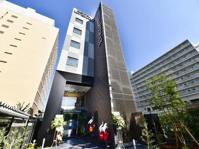 a tall building in the middle of two buildings at HOTEL LiVEMAX Toyosu-Ekimae in Tokyo